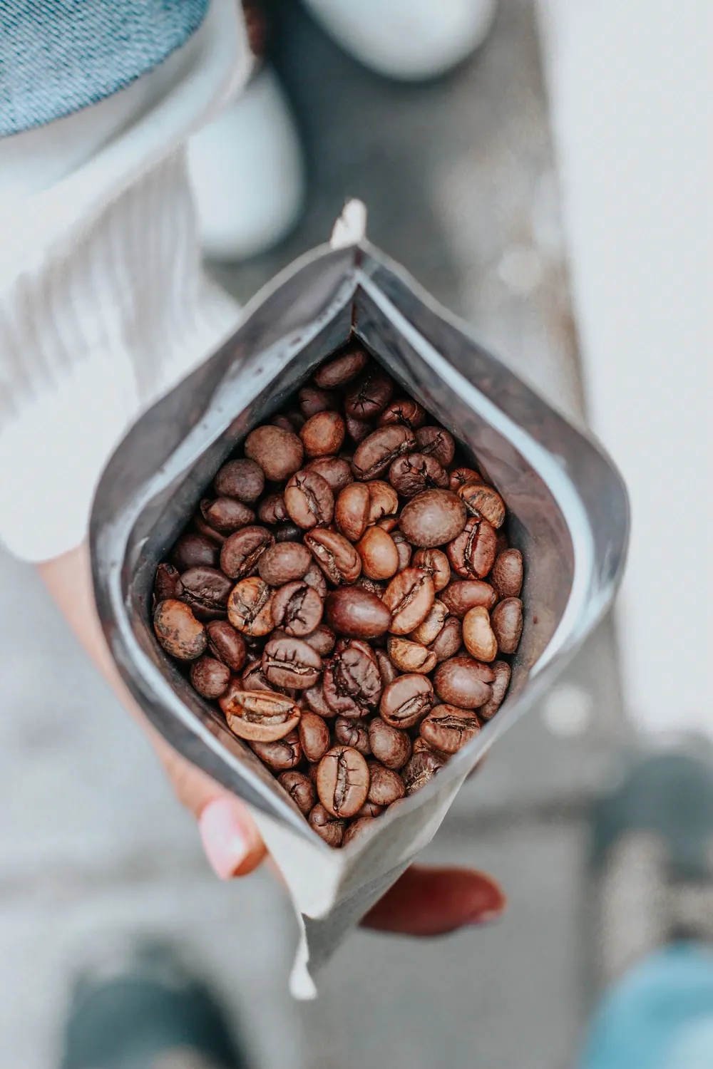 Un sachet ouvert de grains de café torréfiés entiers, vu de dessus