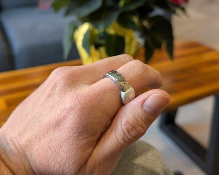 The Index 01 ring in brushed silver at a café table